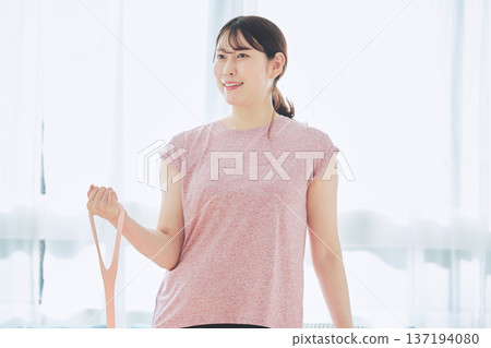 Wellness life of a woman in her 30s exercising at home using training tubes Wellness life of a woman in her 30s exercising at home using training tubes 137194080