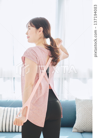 女性在家健身時使用訓練管伸展背部 137194083