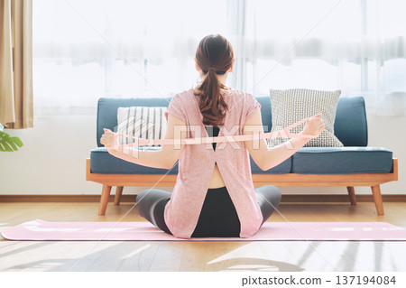 女性在家健身時使用訓練管伸展背部 137194084