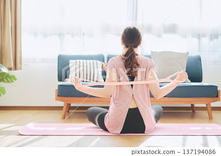 女性在家健身時使用訓練管伸展背部 137194086