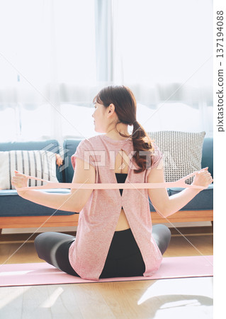 女性在家健身時使用訓練管伸展背部 137194088