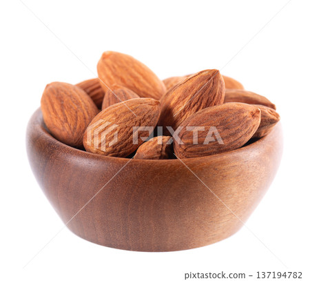 Almond nut isolated on white background. Brown almond nuts in wooden bowl. Clipping path. Almond nut isolated on white background. Brown almond nuts in wooden bowl. Clipping path. 137194782