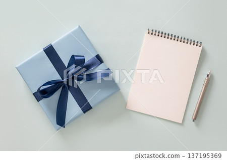 Blue gift box with ribbon and blank notebook 137195369