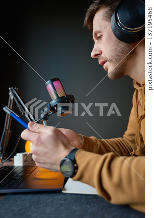 Content creator in home studio with RGB microphone and laptop 137195468
