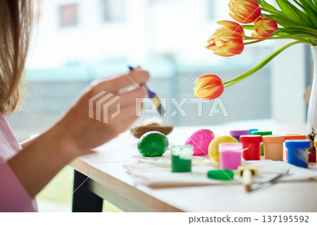 Woman painting Easter egg at home with pastel paints Woman painting Easter egg at home with pastel paints 137195592