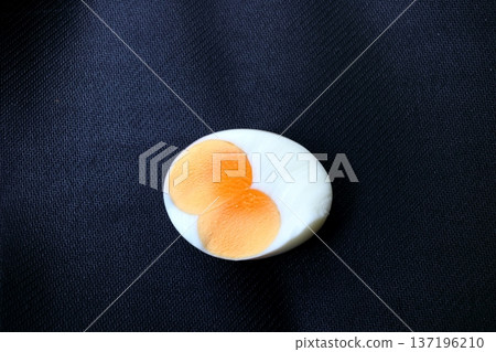 Isolated half boiled twin yolk egg. 137196210