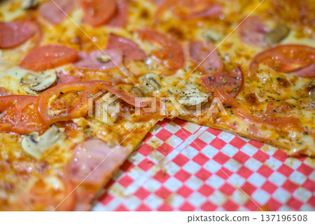 Close-up pizza slices with tomato, ham and mushrooms Close-up pizza slices with tomato, ham and mushrooms 137196508