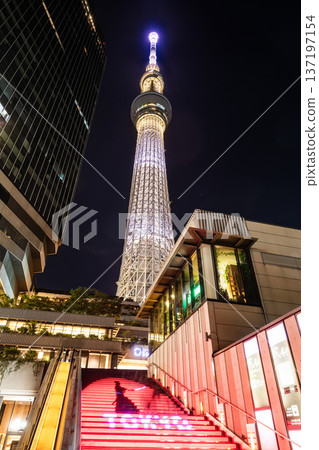 Night view of Tokyo Skytree, with beautiful reflections of the majestic tower in the Sumida River, it's the primary television and radio broadcast site in the Kanto region, Japan. Night view of Tokyo Skytree, with beautiful reflections of the majestic tower in the Sumida River, it's the primary television and radio broadcast site in the Kanto region, Japan. 137197154