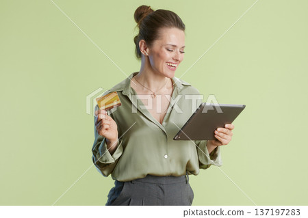 Woman smiling with credit card and tablet 137197283