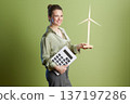 Happy About Green Energy: Woman, Turbine, and Calculator 137197286