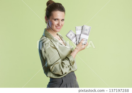Smiling woman holding stacks of money Smiling woman holding stacks of money 137197288