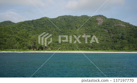 View form boat of Seychelles La Digue Island with sandy beach and lush forest in January 137197770
