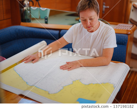 Woman Sailor Studying Navigation Map Inside Yacht Cabin Interior Woman Sailor Studying Navigation Map Inside Yacht Cabin Interior 137198182
