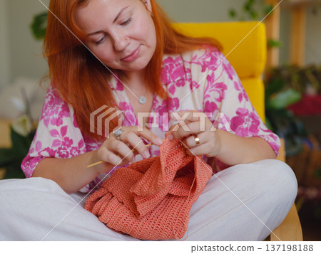 Young Woman knitting in living room 137198188