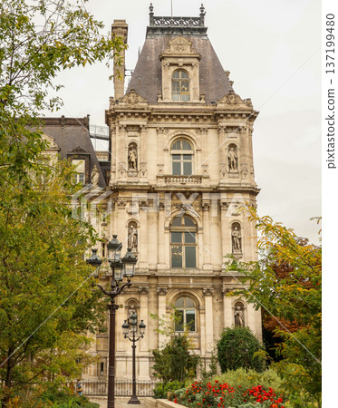 Hotel de Ville in Paris, France, showing Renaissance architecture, ornate details, and garden with red flowers 137199480