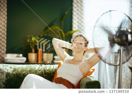 Relaxed Woman Enjoying Fan Breeze in Summer Relaxed Woman Enjoying Fan Breeze in Summer 137199550