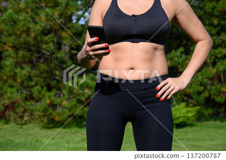 Woman using smartphone to study yoga exercises after morning practice Woman using smartphone to study yoga exercises after morning practice 137200787