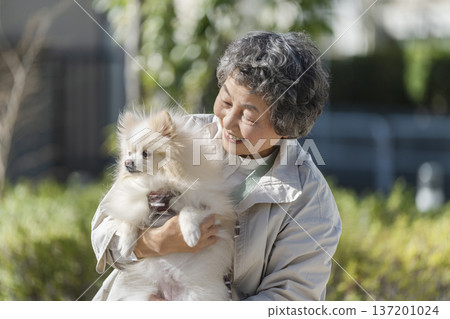 老婦人抱著她的寵物狗 老婦人抱著她的寵物狗 137201024
