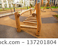 Modern wooden rope bridge on a children's playground. Outdoor entertainment and childhood adventure concept. Safe play equipment for kids. 137201804