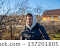young white man, agricultural worker with rake on sunny autumn day on organic farm. Portrait from the waist up. Farm work, harvest, cleaning, gardening 137201805