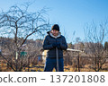Man gardener standing with shovel and looking at ground. Farmer concept for gardening and agriculture in spring or autumn. organic farm 137201808