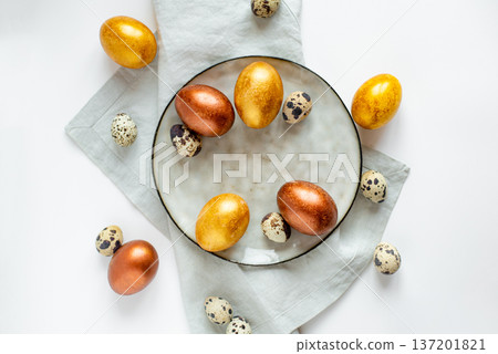 Golden and bronze Easter eggs in a grey plate 137201821