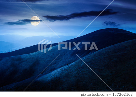 scenic mountain landscape in summer at night. beautiful travel background with rolling hills. lush green grassy hillside in full moon dappled light. narrow telephoto view. mysterious fantasy scenic mountain landscape in summer at night. beautiful travel background with rolling hills. lush green grassy hillside in full moon dappled light. narrow telephoto view. mysterious fantasy 137202162