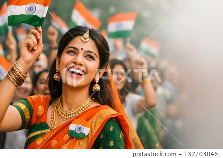 Happy woman in traditional saree waving Indian flag, celebrating Independence Day with crowd. 137203046