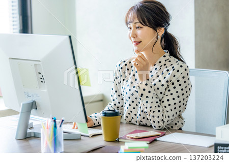 Young woman operating a computer in the office 137203224