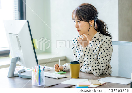 Young woman operating a computer in the office Young woman operating a computer in the office 137203226