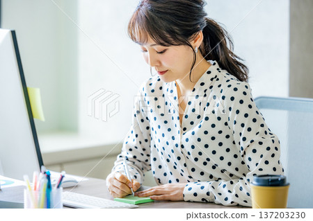 Young woman operating a computer in the office 137203230