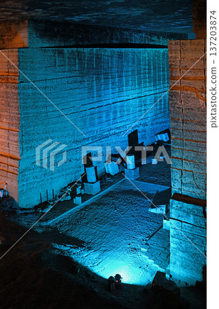 A mysterious underground labyrinth of blue light, with towering stone walls. 137203874