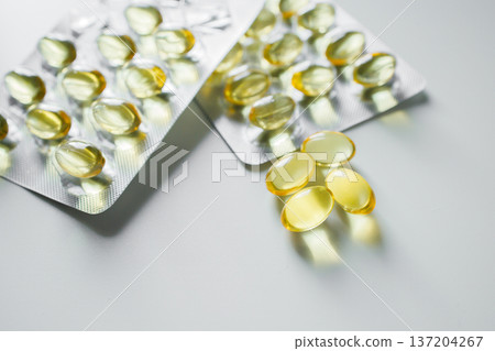 Omega 3 fish oil capsules in blisters on white table close up. Vitamins and supplements, healthcare and medicine. 137204267