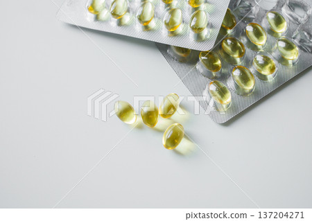 Omega 3 fish oil capsules in blisters on white table close up. Vitamins and supplements, healthcare and medicine. 137204271