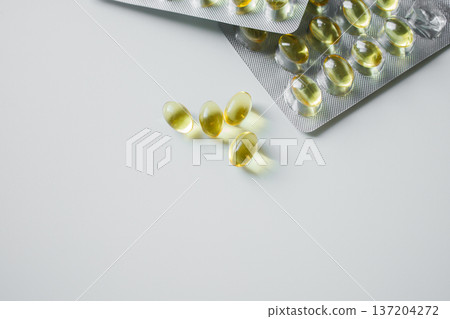 Omega 3 fish oil capsules in blisters on white table close up. Vitamins and supplements, healthcare and medicine. 137204272