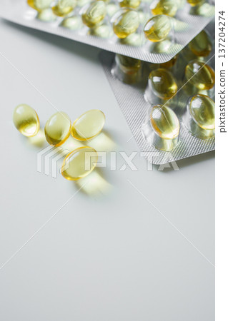 Omega 3 fish oil capsules in blisters on white table close up. Vitamins and supplements, healthcare and medicine. 137204274