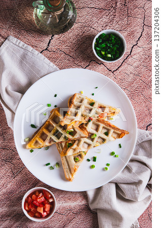 Bacon, cheese and tomatoes baked in waffle bread on a plate on the table top and vertical view Bacon, cheese and tomatoes baked in waffle bread on a plate on the table top and vertical view 137204306