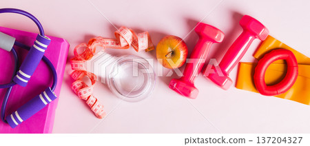 A glass of water and an apple for a diet and sports equipment on the table top view web banner A glass of water and an apple for a diet and sports equipment on the table top view web banner 137204327