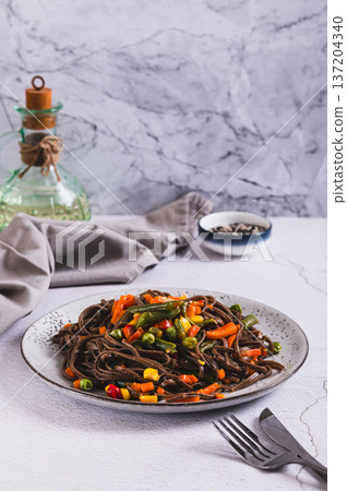 Vegetarian soba with mexican mixed vegetables on a plate on the table vertical view 137204340