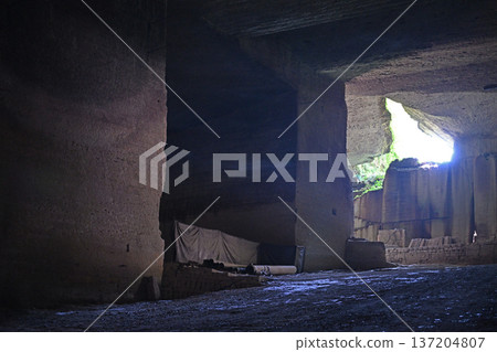 A ray of natural light filtering into the huge cavern of an underground mine 137204807