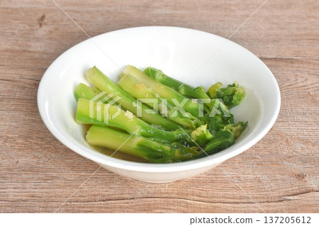 fried Kailaan Chinese kale dressing oyster sauce with chop garlic and salty fish on bowl 137205612