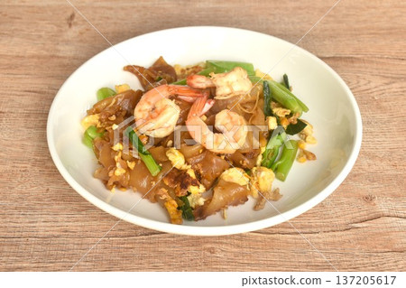 stir fried large rice noodles with shrimp and Chinese kale dressing black sweet soybean sauce on plate 137205617