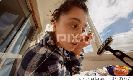 City resident applying mascara outside during morning rush City resident applying mascara outside during morning rush 137205837