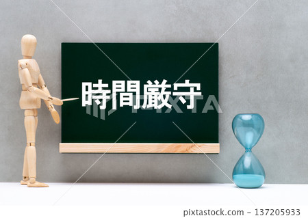 黑板上用沙漏和畫娃娃畫著「準時」兩個字。 黑板上用沙漏和畫娃娃畫著「準時」兩個字。 137205933