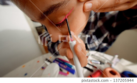 Beauty artist preparing. Stylist carefully applying eyeliner on model Beauty artist preparing. Stylist carefully applying eyeliner on model 137205944
