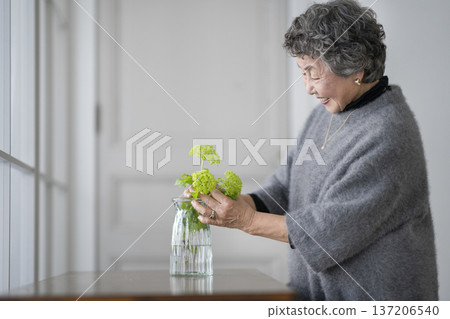 老婦人用鮮花裝飾房間 老婦人用鮮花裝飾房間 137206540