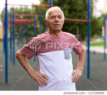 Senior man in sportswear standing in outdoor playground Senior man in sportswear standing in outdoor playground 137206666