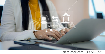 Businesswoman using laptop for online banking and money transfer with virtual holographic interface showing payment successful notification and financial icons. 137206775