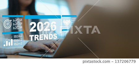 Businesswoman using laptop to analyze 2026 trends with virtual digital interface showing business goals, data graphs, and partnership icons in a modern office. Businesswoman using laptop to analyze 2026 trends with virtual digital interface showing business goals, data graphs, and partnership icons in a modern office. 137206779