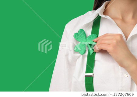 Young woman wears a green clover pin on her shirt 137207609